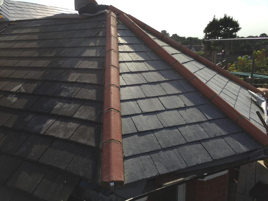 Dark tiled pitched roof and ridge line photographed from roof level