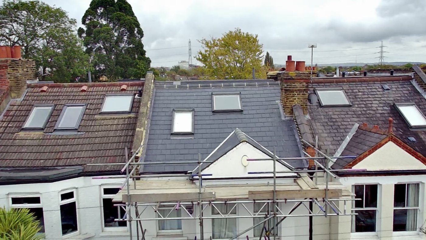 Grey slate-style roof between neighbouring houses with scaffolding in place