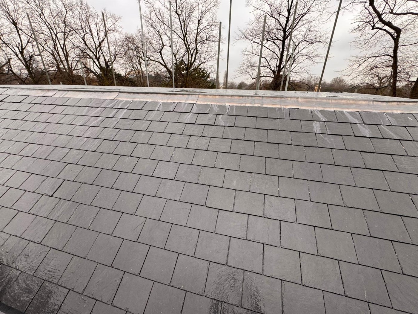 Dark slate-style roof covering with ridge detail