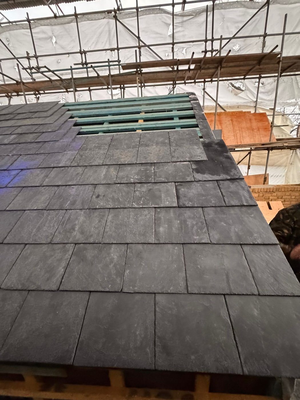 Partially installed slate-style roof covering with exposed battens
