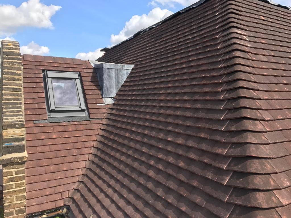 Brown tiled pitched roof with rooflight and adjoining roof slope