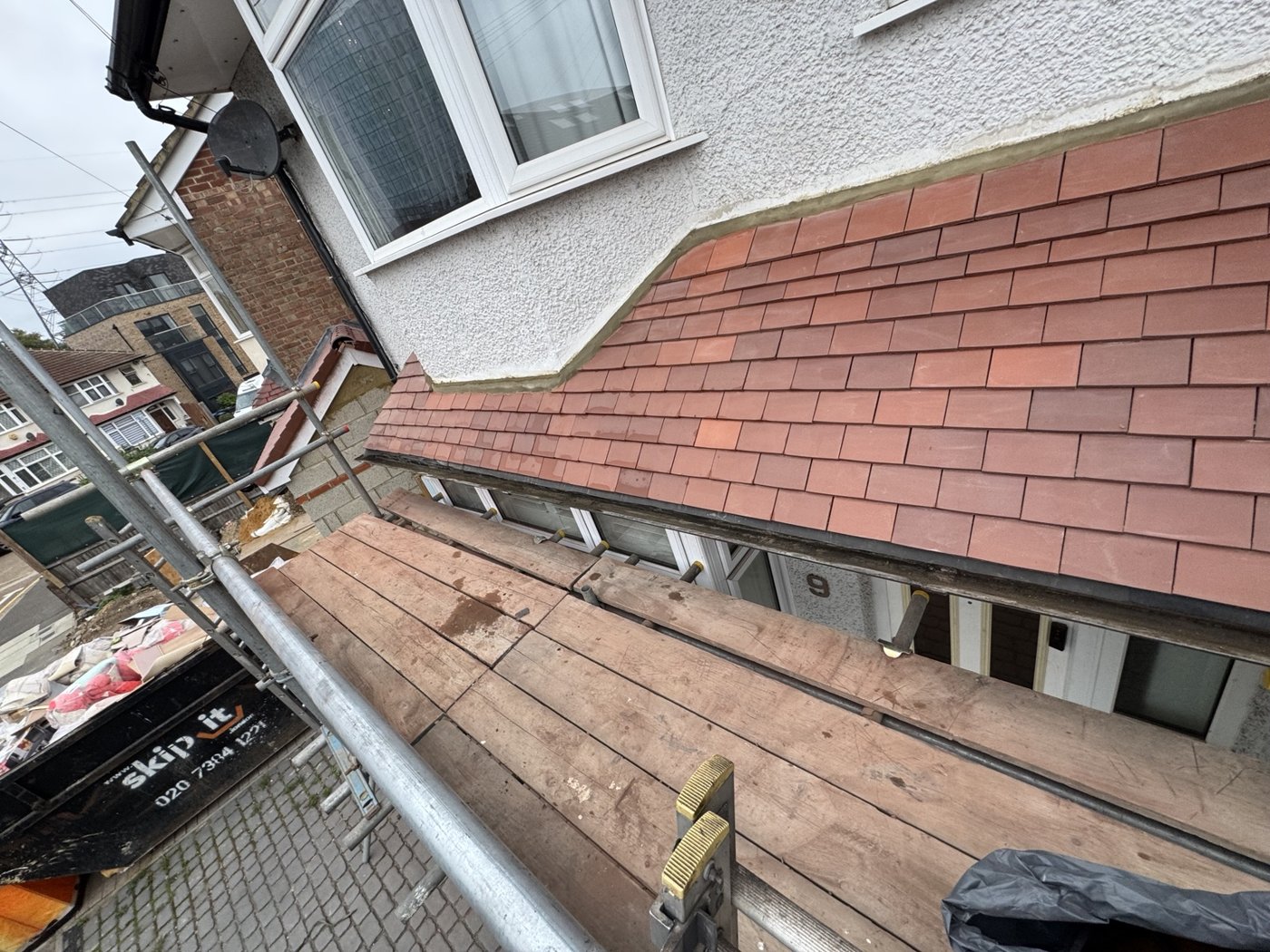 Red tiled roof beside a dormer with scaffolding in place