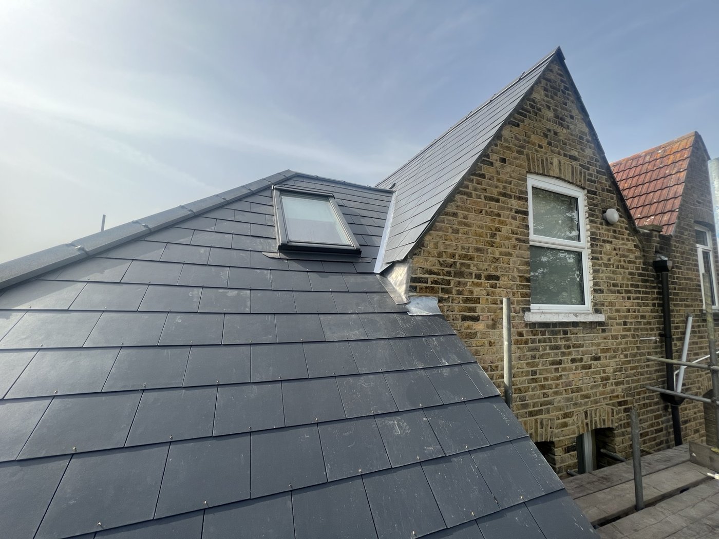 Grey slate-style pitched roof with a rooflight and lead flashing detail